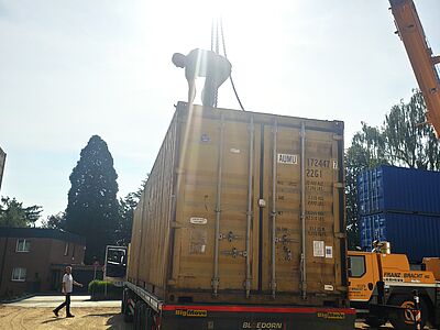 Per Kran werden die Seecontainer in drei Lagen zu einer Schutzwand gestapelt