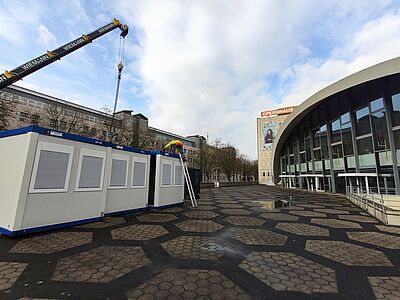 Raumcontainer werden per Kran abgeholt